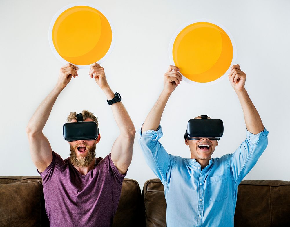Men enjoying VR goggles on a couch