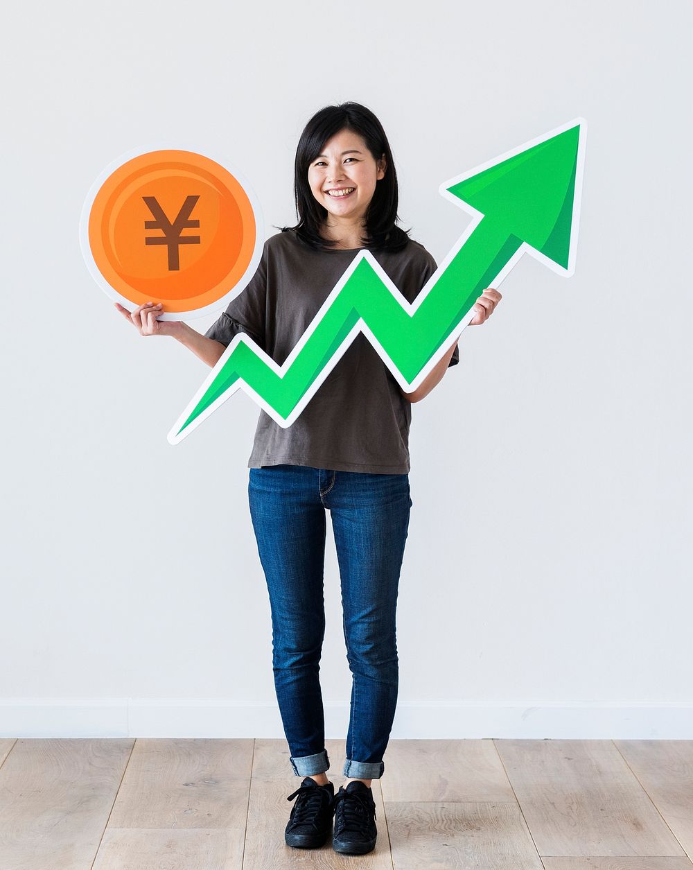 Happy Asian woman holding a Japnese Yen and financial growth arrow