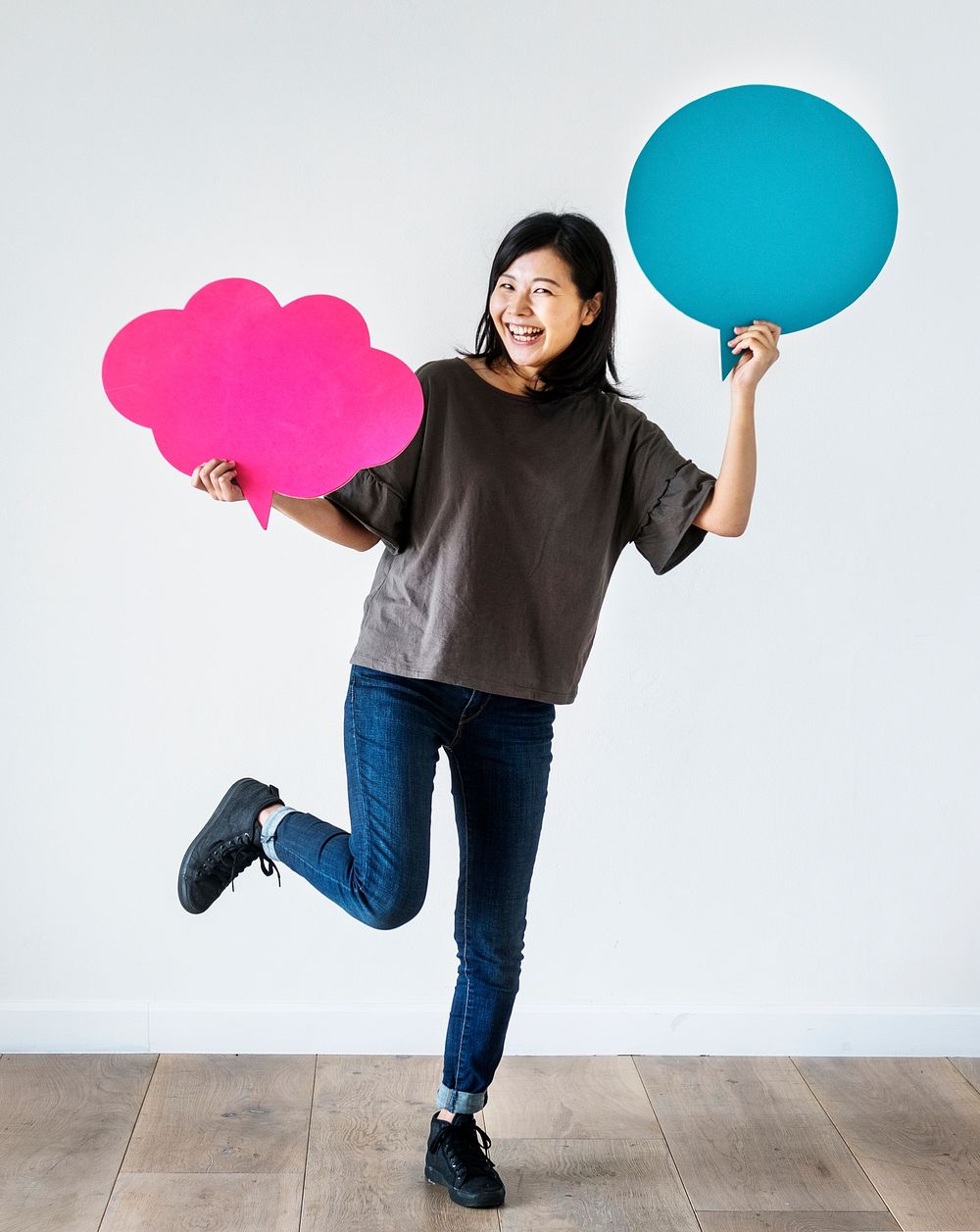 Happy Asian woman holding copyspace speech bubble
