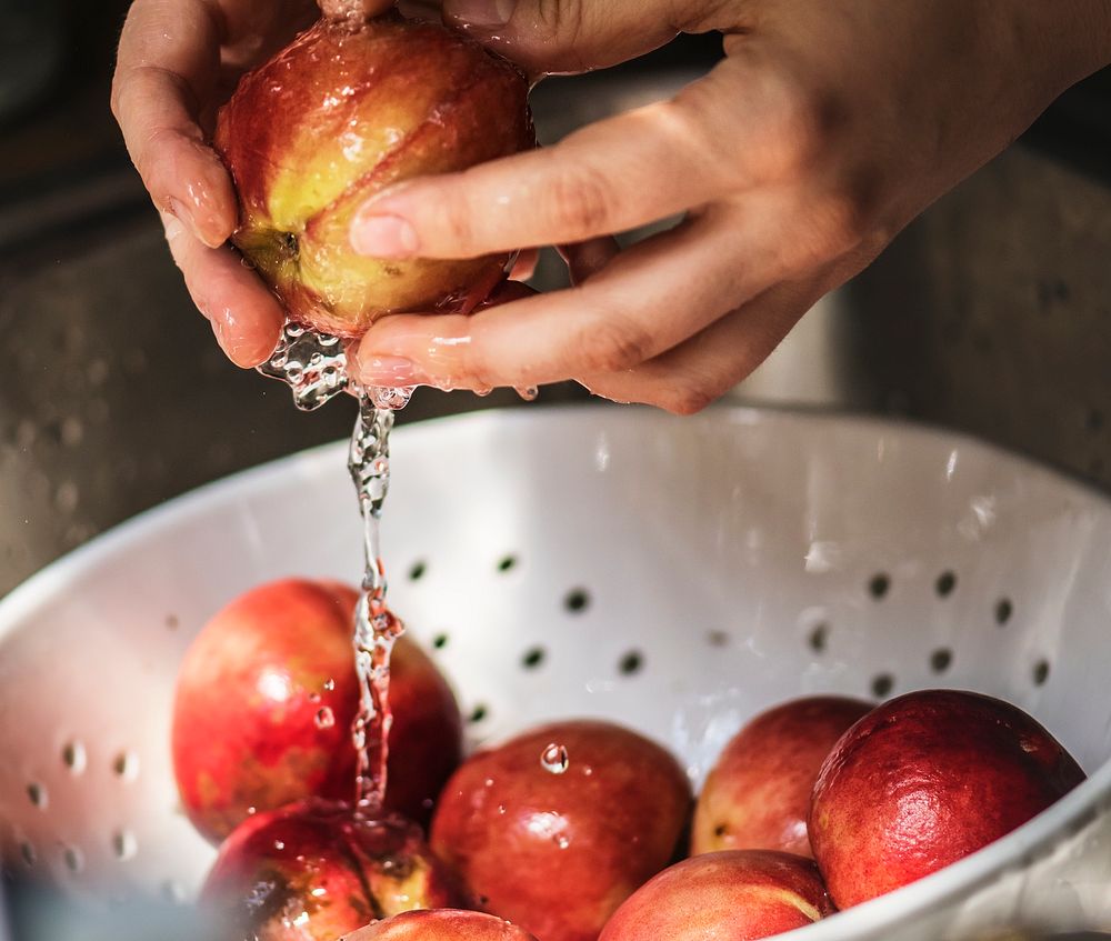 Person washing pomegranate under running water food photography idea