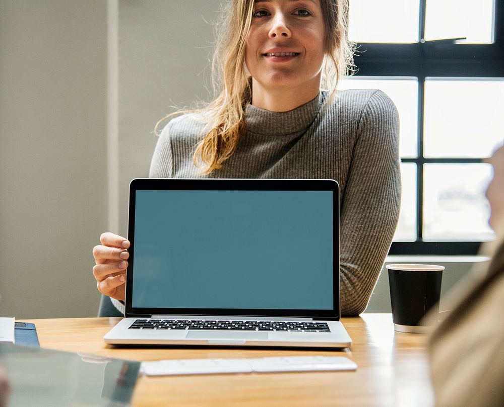 Happy woman with a blank laptop screen