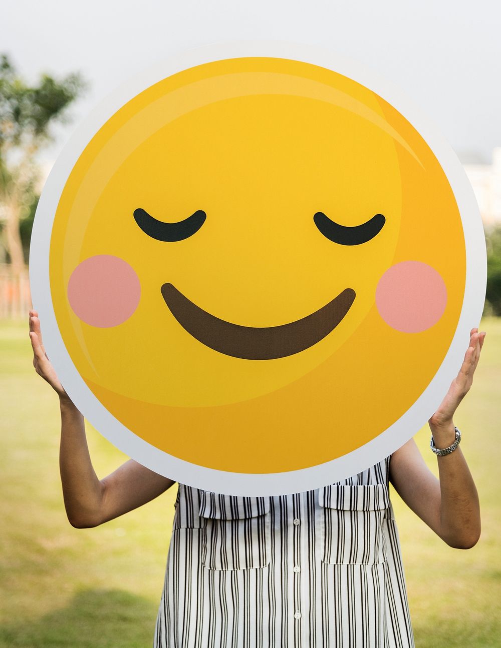 Woman holding a smiley face icon