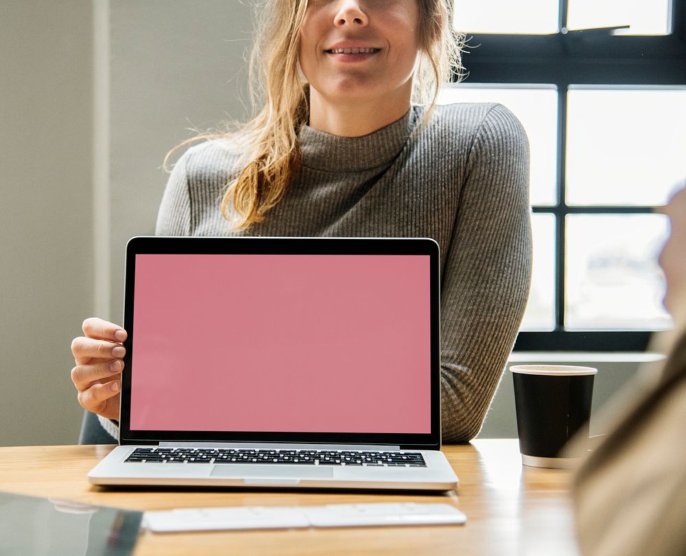 Blond woman pointing at a laptop screen