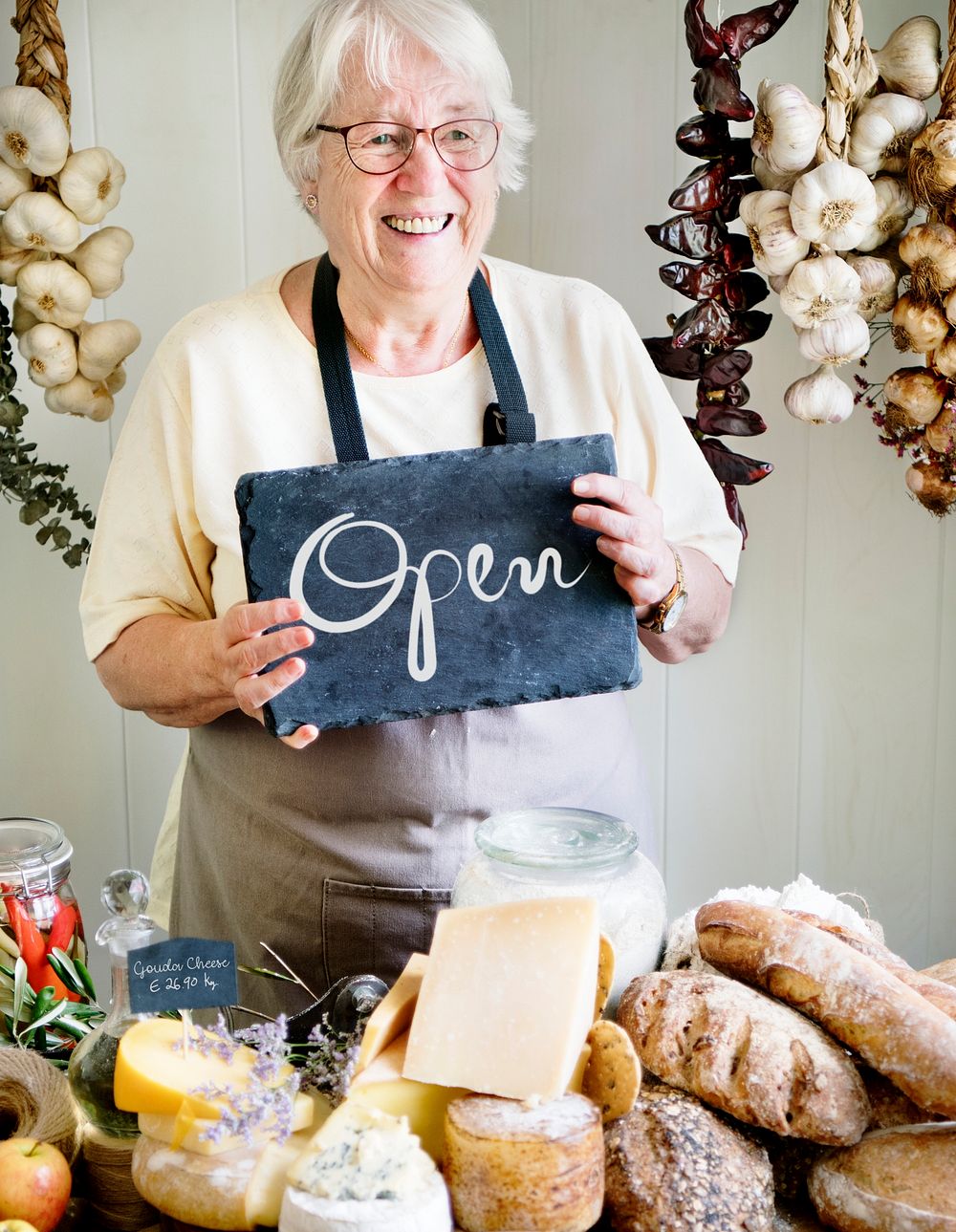 Elderly woman holding an open sign