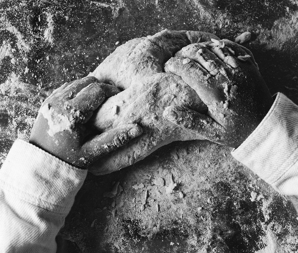 Hands of a child kneading dough in the kitchen