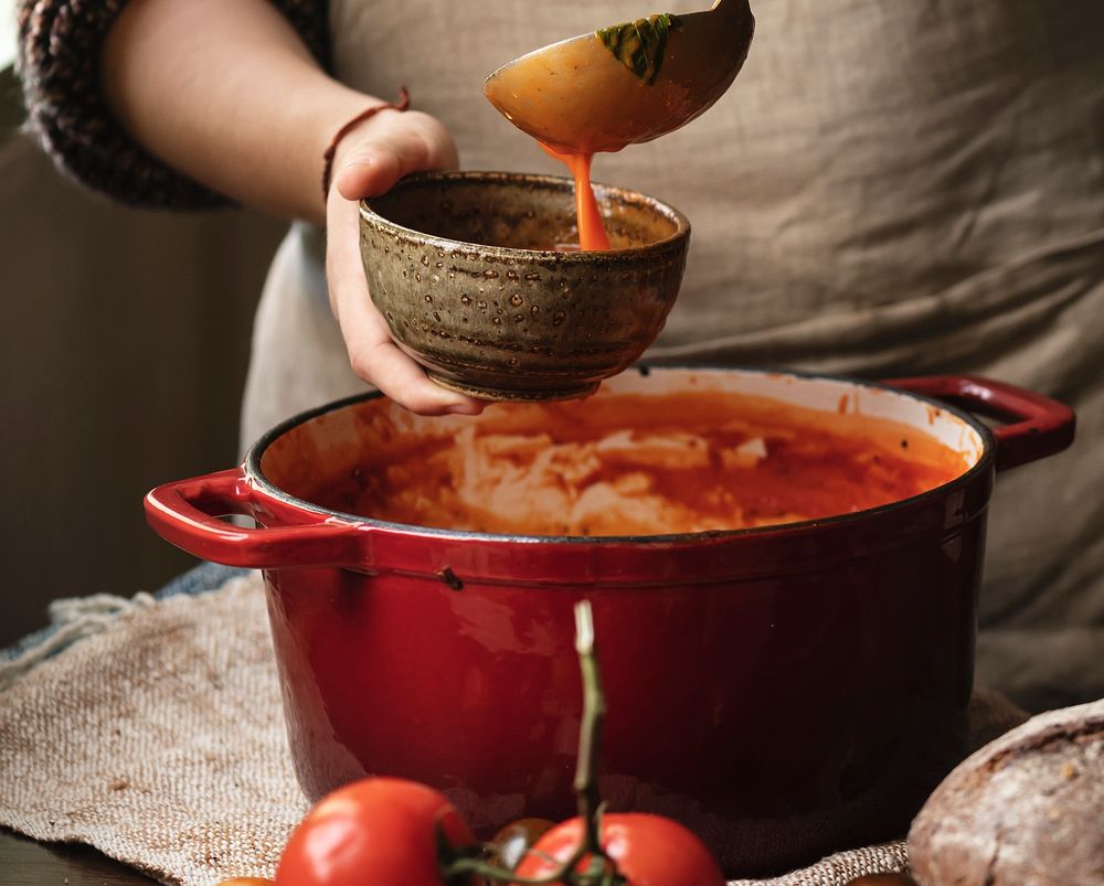 Woman pouring tomato soup into a bowl
