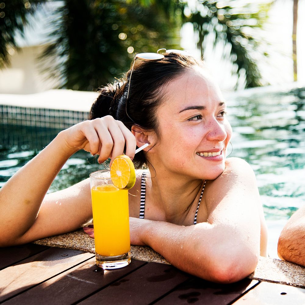 A woman in a pool with an orange juice