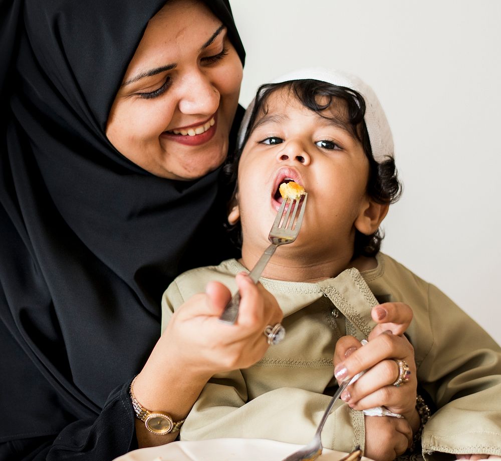 Muslim woman feeding her son