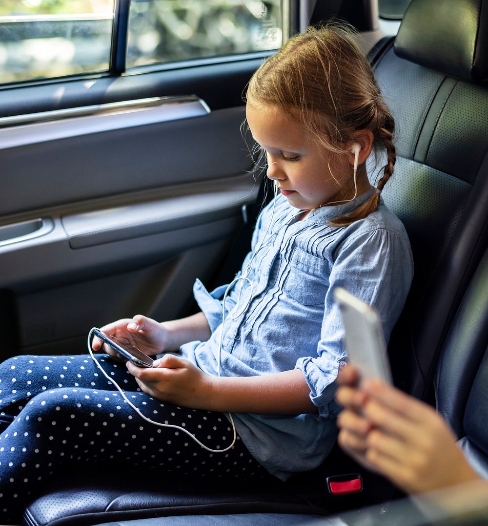 Girl in a car using a digital device