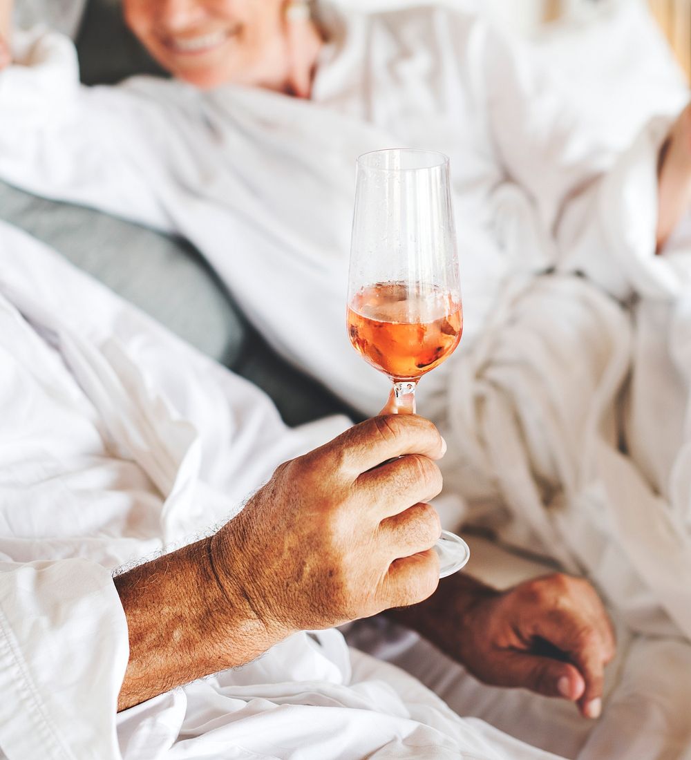 Couple having prosecco in bed