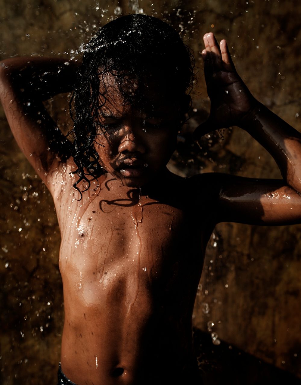 African kid showering in outdoor shower