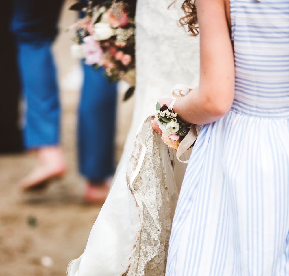 Flower girl holding brides wedding dress