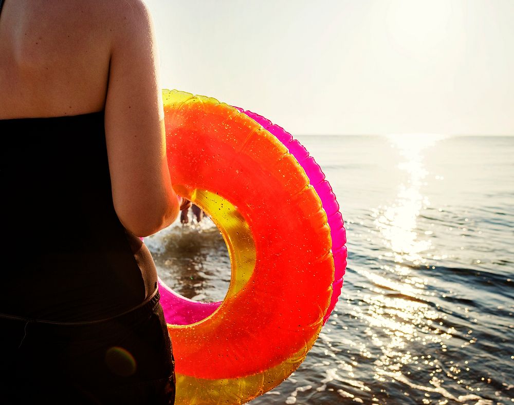 Woman carrying a swimming ring to the beach