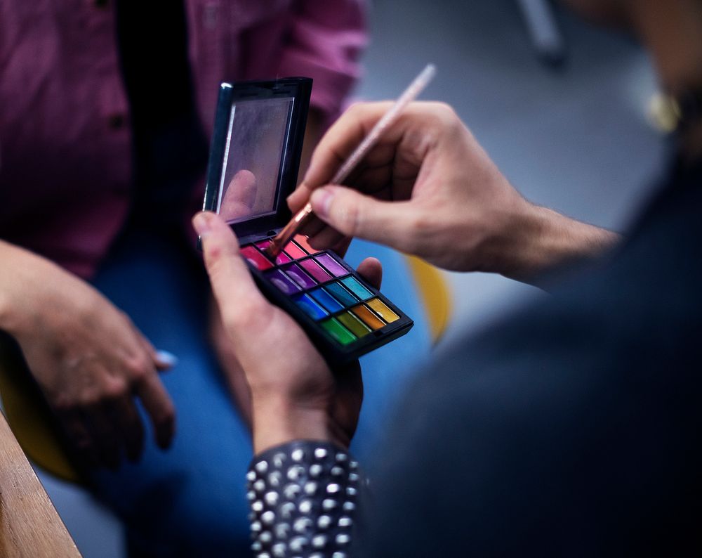 Makeup artist holding a colorful eyeshadow palette