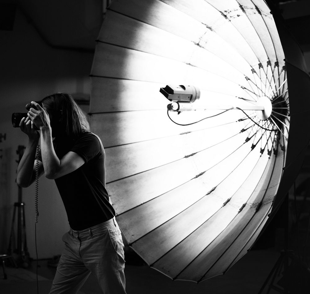 Young photographer standing in front of a reflective umbrella