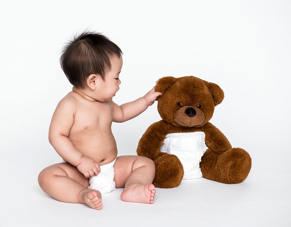Studio shot of a baby with a teddy bear
