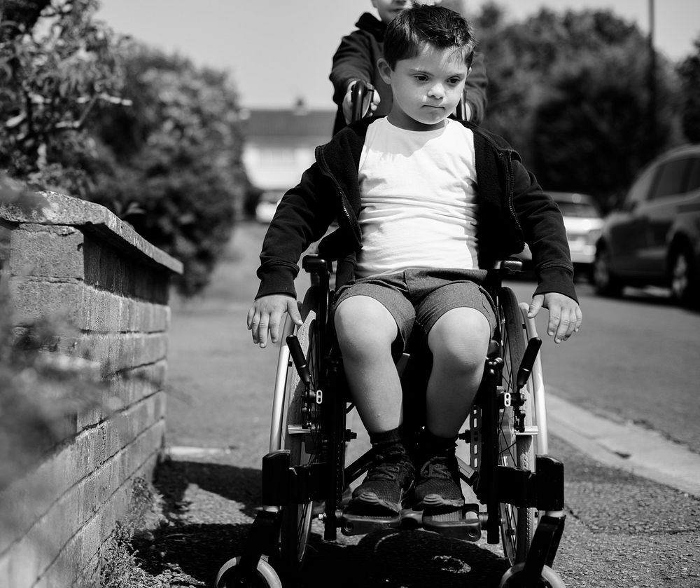 Boy pushing his brother in a wheelchair