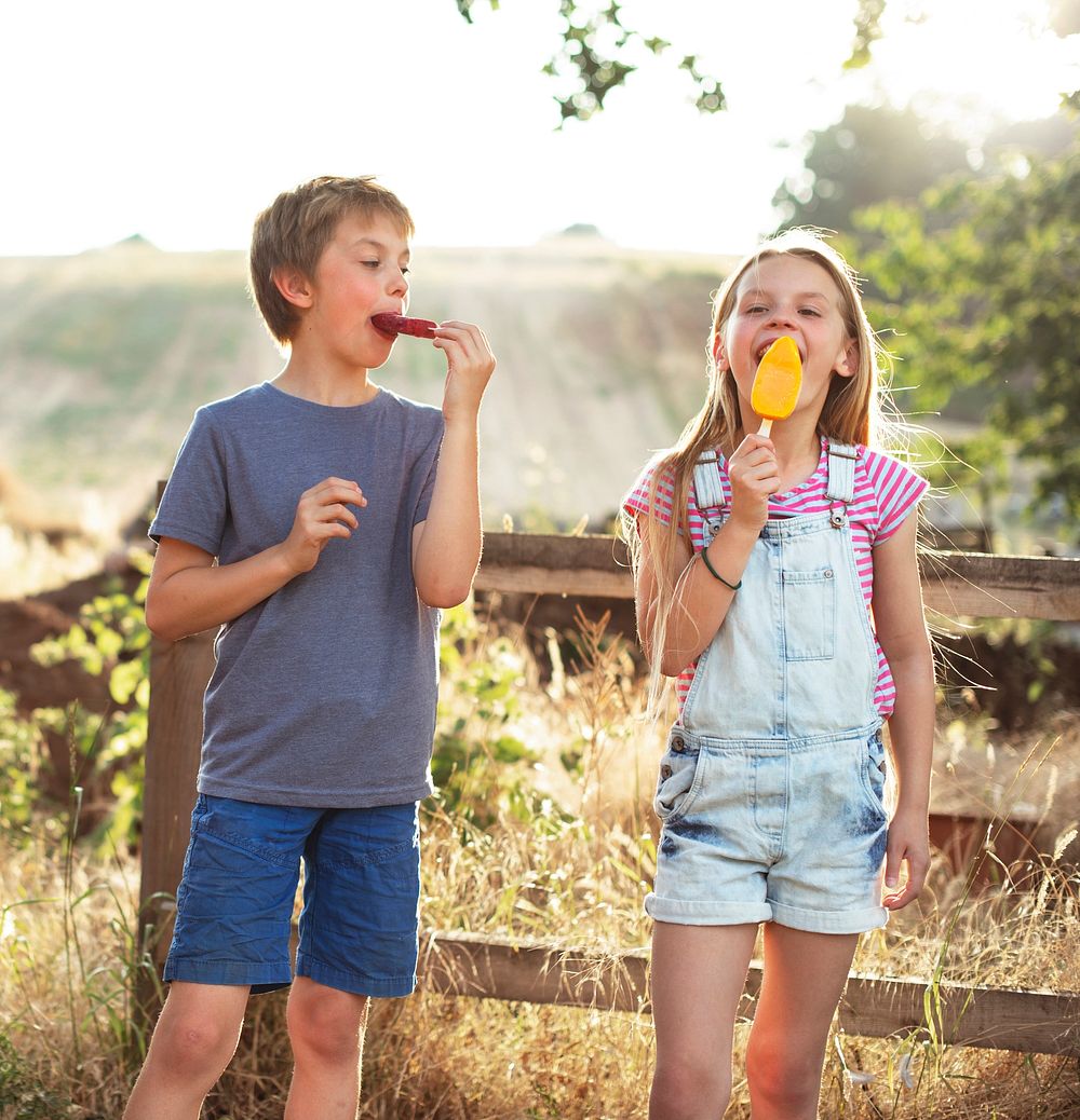 Kids eating ice popsicles in the summer
