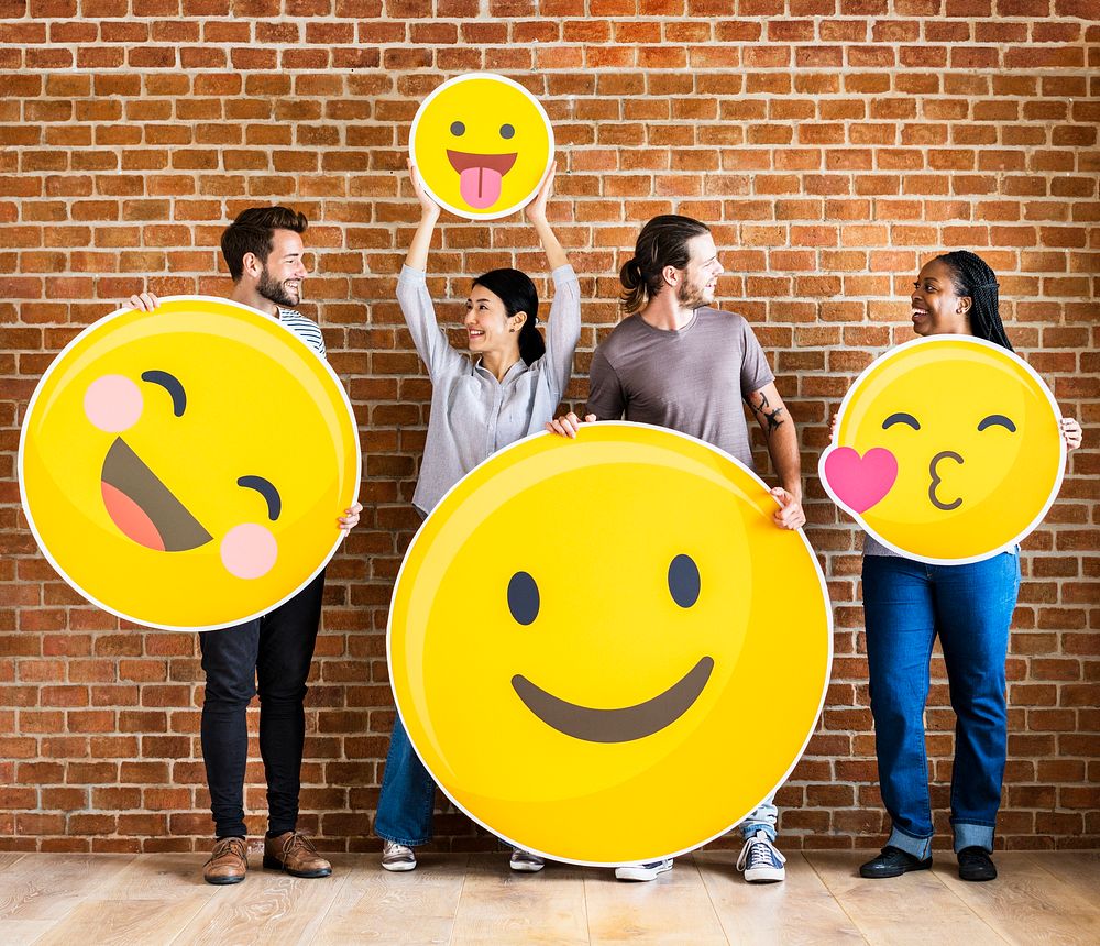 Diverse people holding positive emoticons