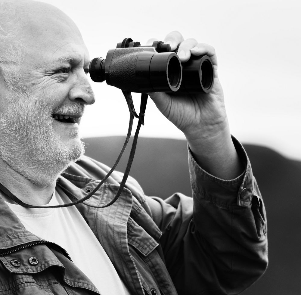 Close up of an old man with a pair of binoculars