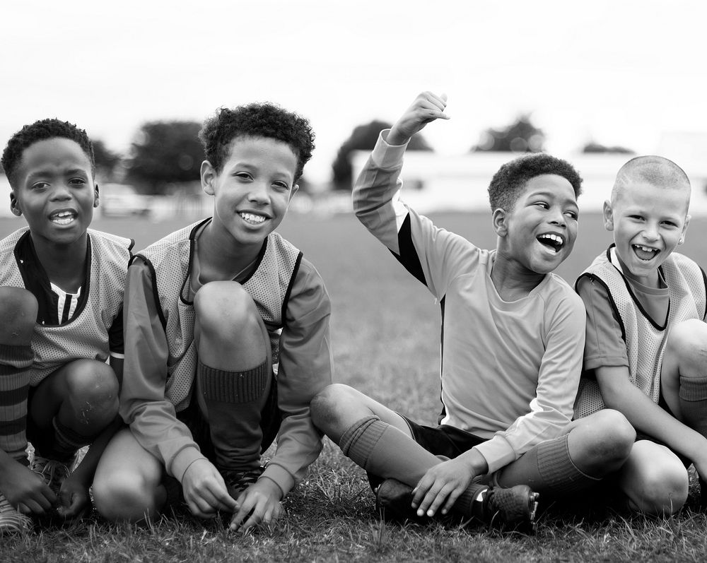 Enthusiastic football players sitting on the field