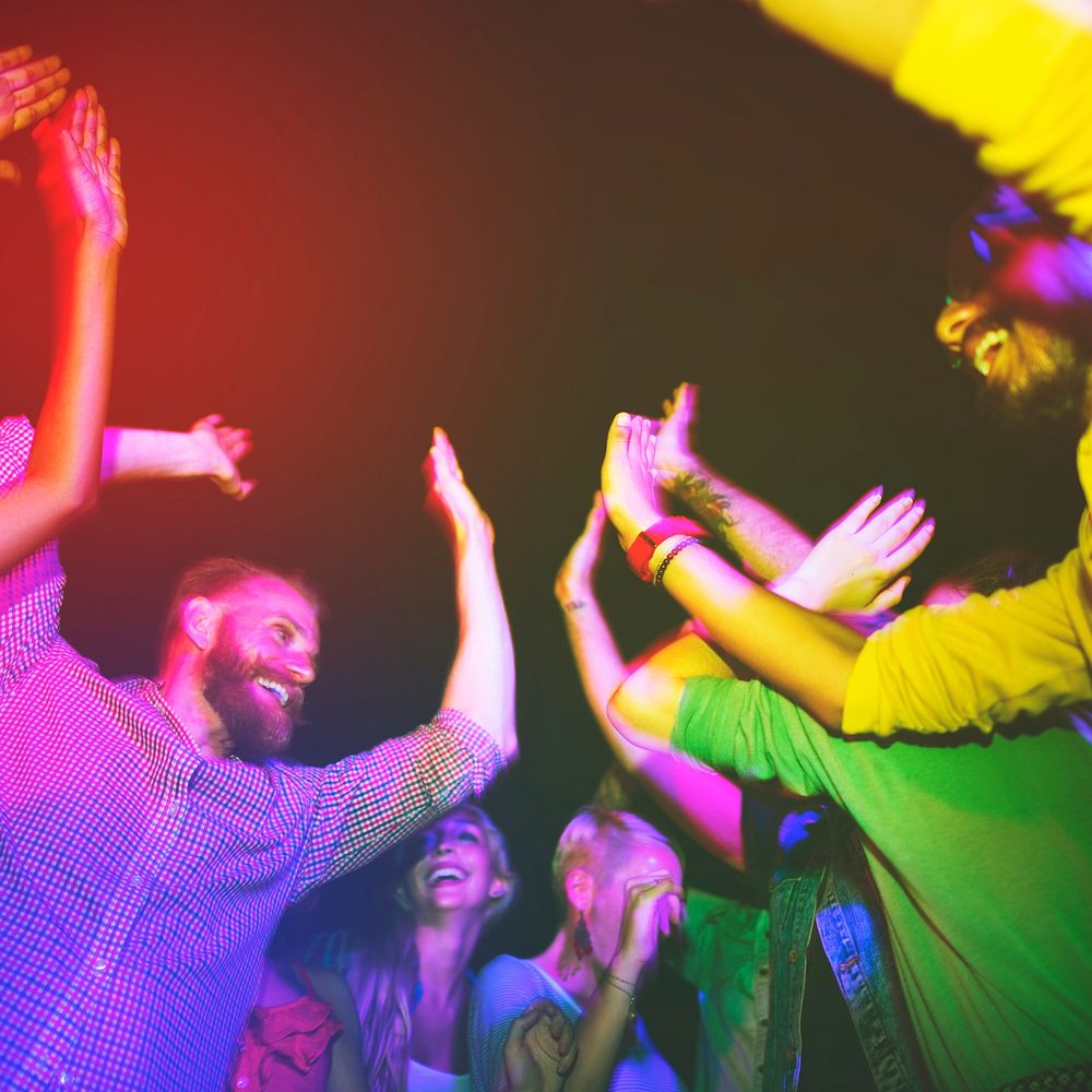 Happy party people dancing outdoors