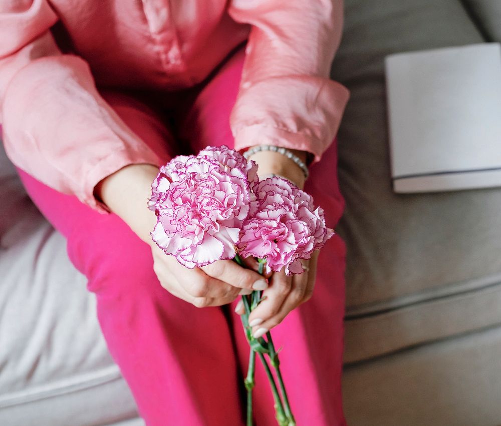 Woman holding white and pink carnations
