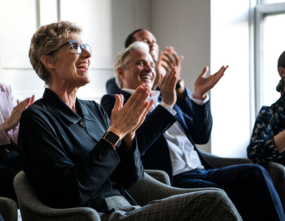 Happy business people applauding in a seminar