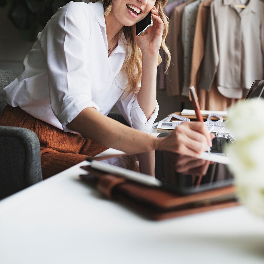 Fashion designer on the phone and taking notes