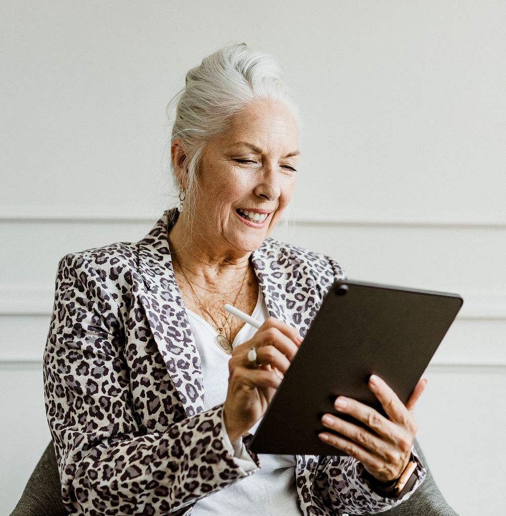 Elderly businesswoman taking note with stylus on a digital rablet