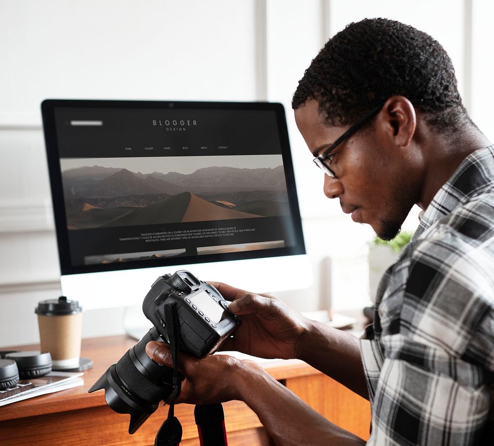 Black photographer sitting by his computer screen mockup