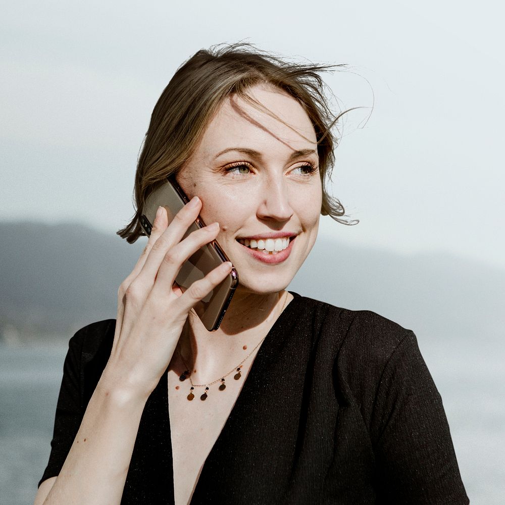 Happy woman talking on a phone mockup by the beach