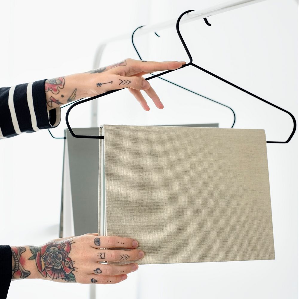 Tattooed woman hanging books mockup on a hanger