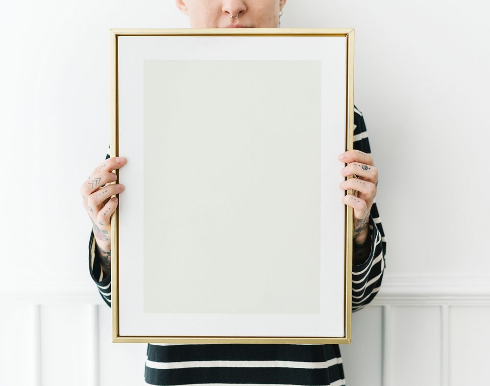 Tattooed woman holding a blank photo frame