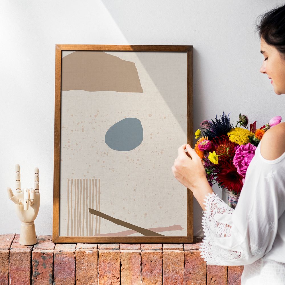 Girl decorating a wall with a frame