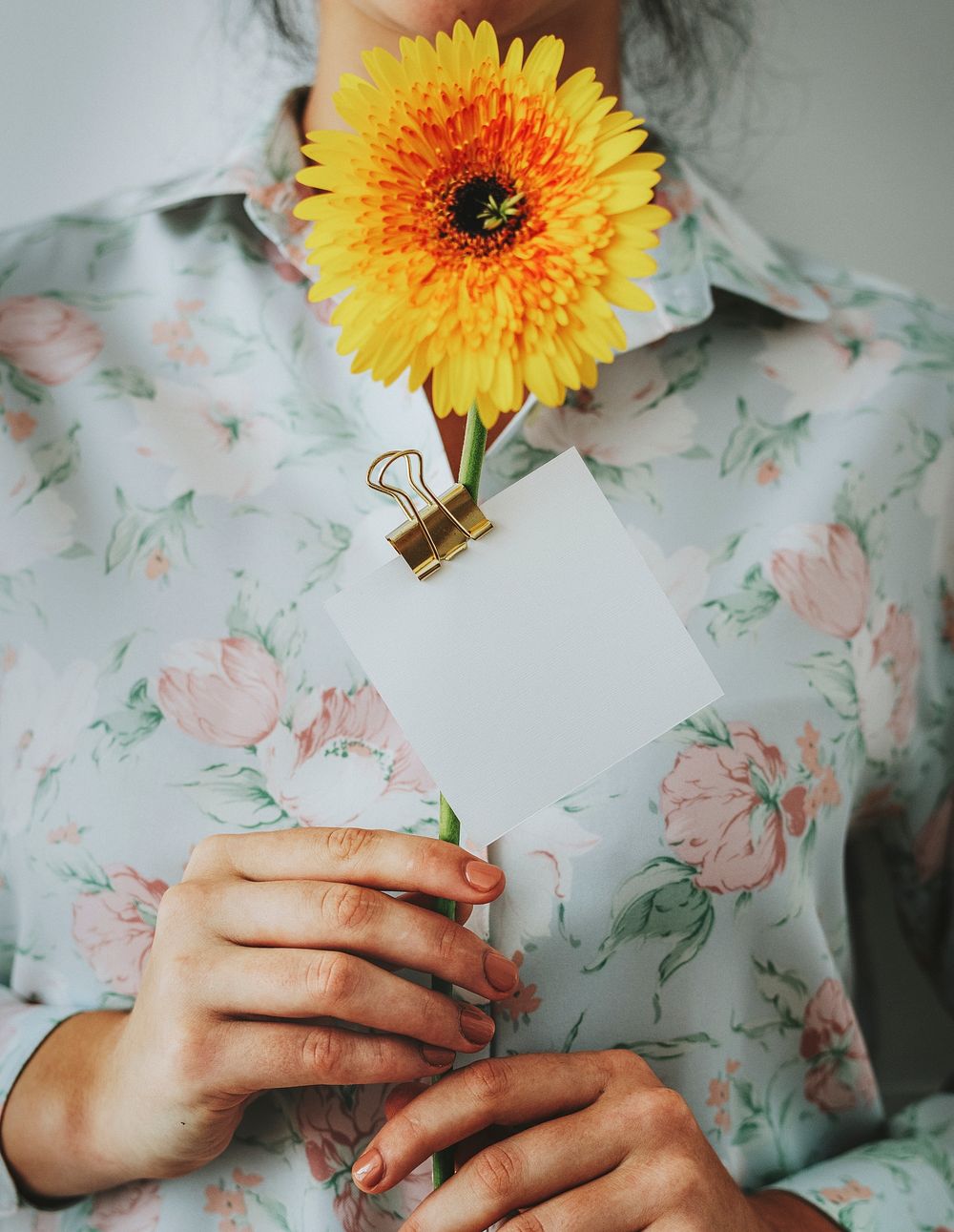 Girl holding a Gerbera with a blank card