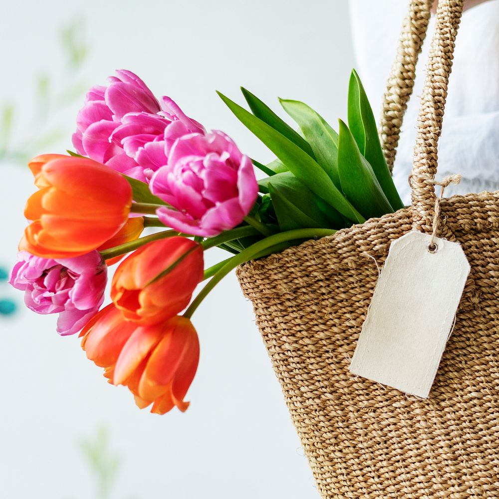 Woman carrying tulips in a wicker bag