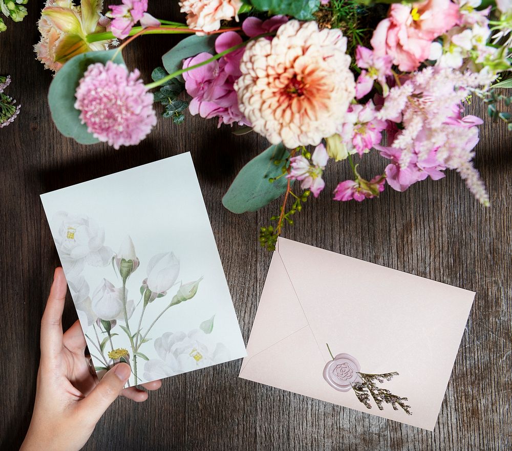 Woman holding a card mockup by a bouquet of flowers