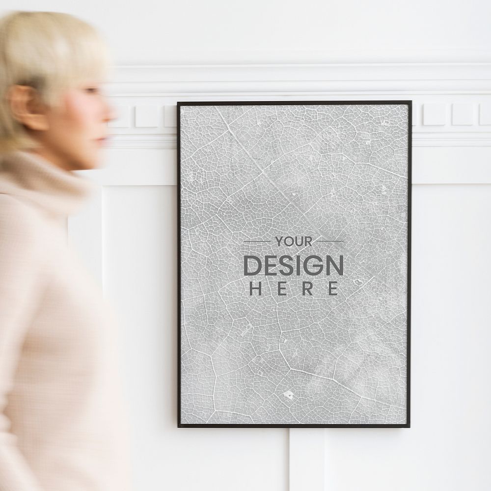 Woman walking past a black photo frame on a white wall mockup