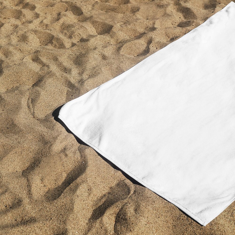 White beach towel psd mockup laying on the sand