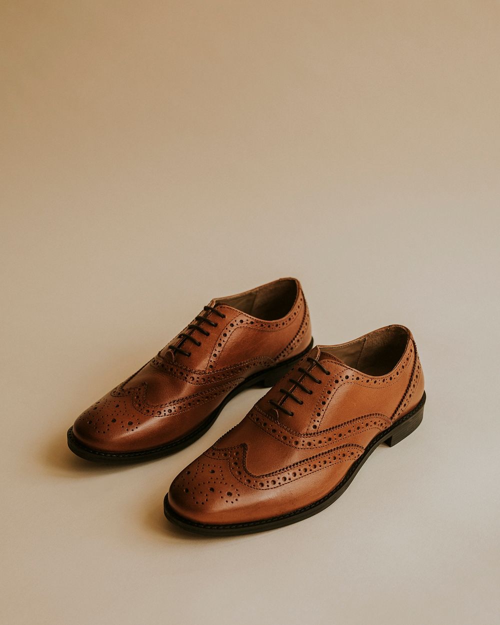 Men's brown leather derby shoes on beige