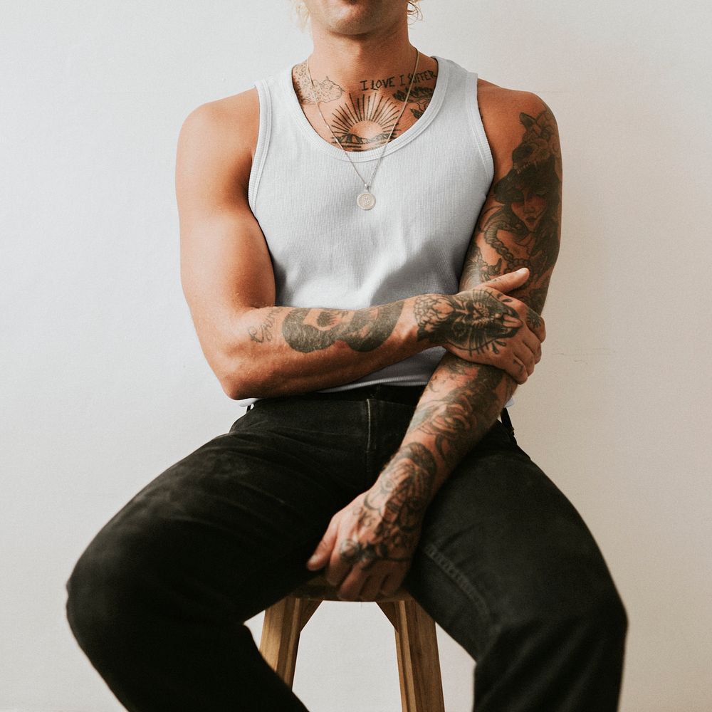 Handsome man in white tank top and black pants studio shot