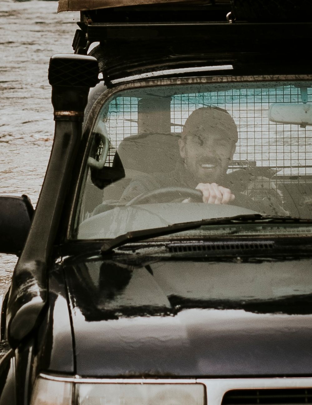 Happy man driving through the flood