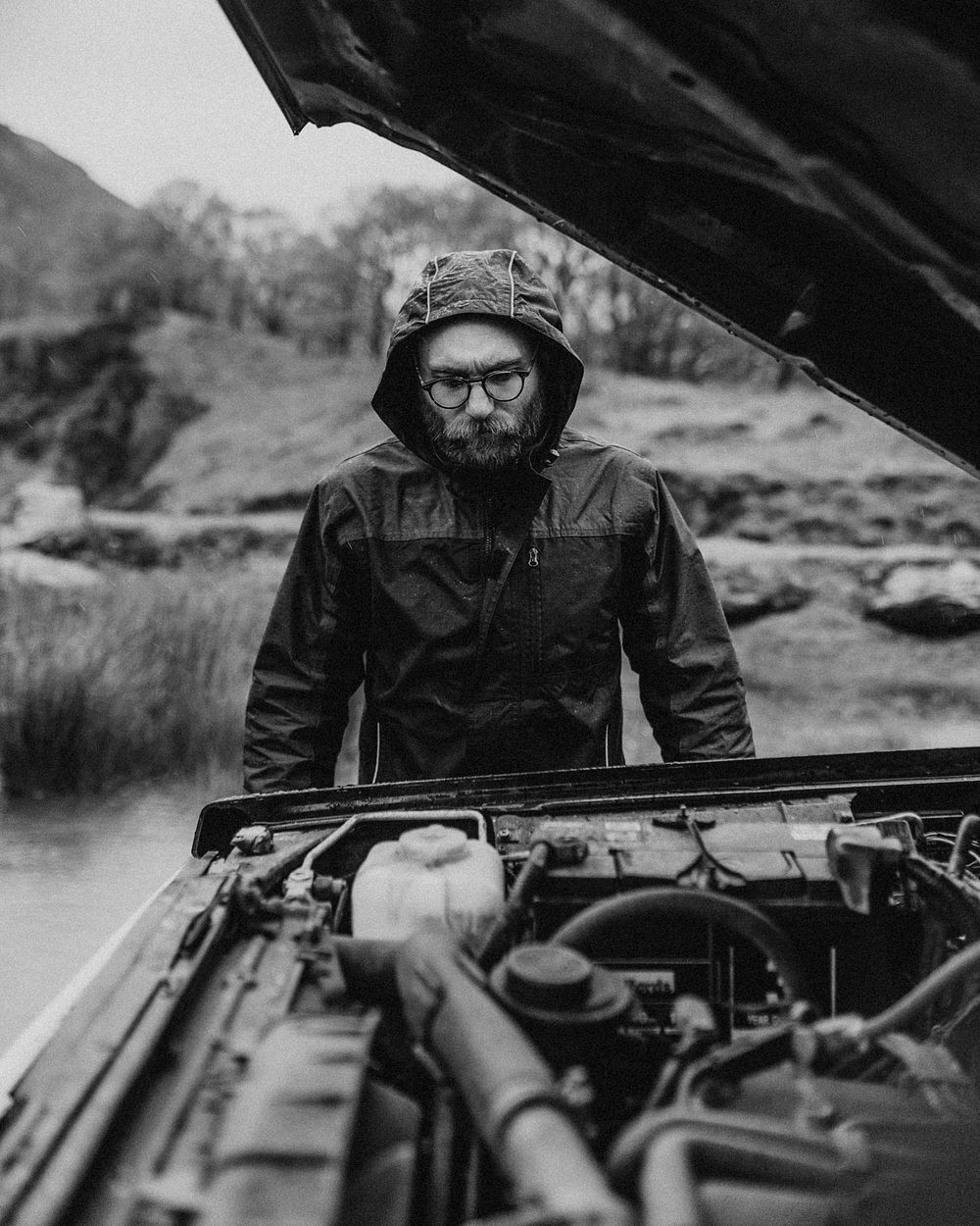 Auto mechanic fixing car engine outdoors