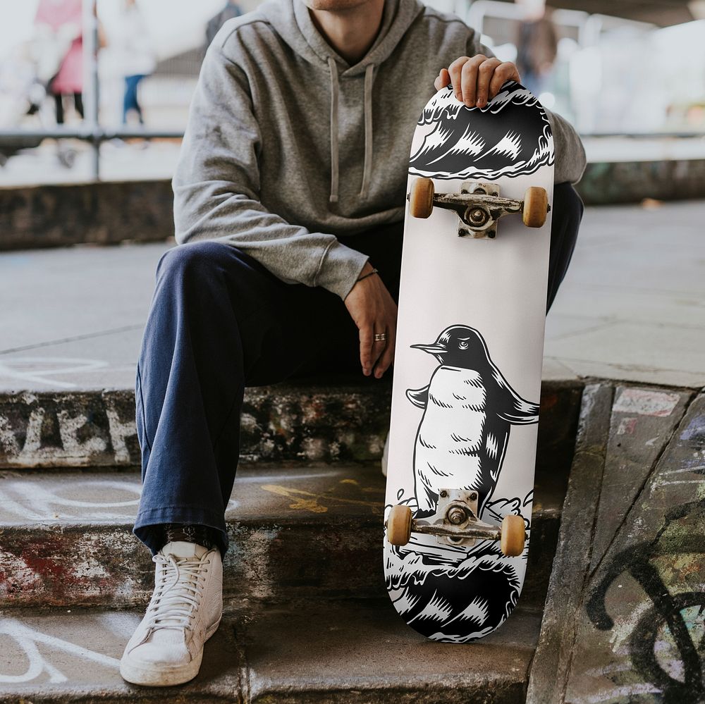 Man with patterned skateboard sitting on steps
