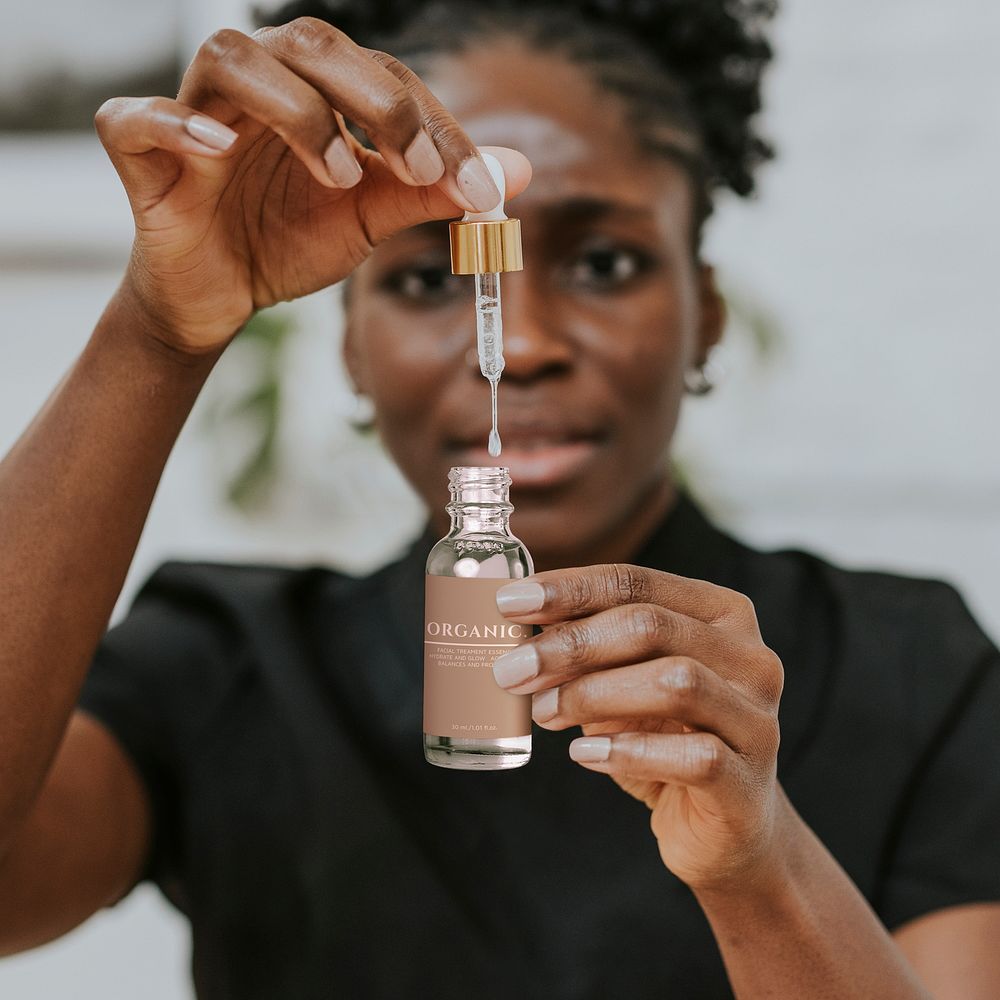 Serum bottle mockup in African American woman&rsquo;s hands psd