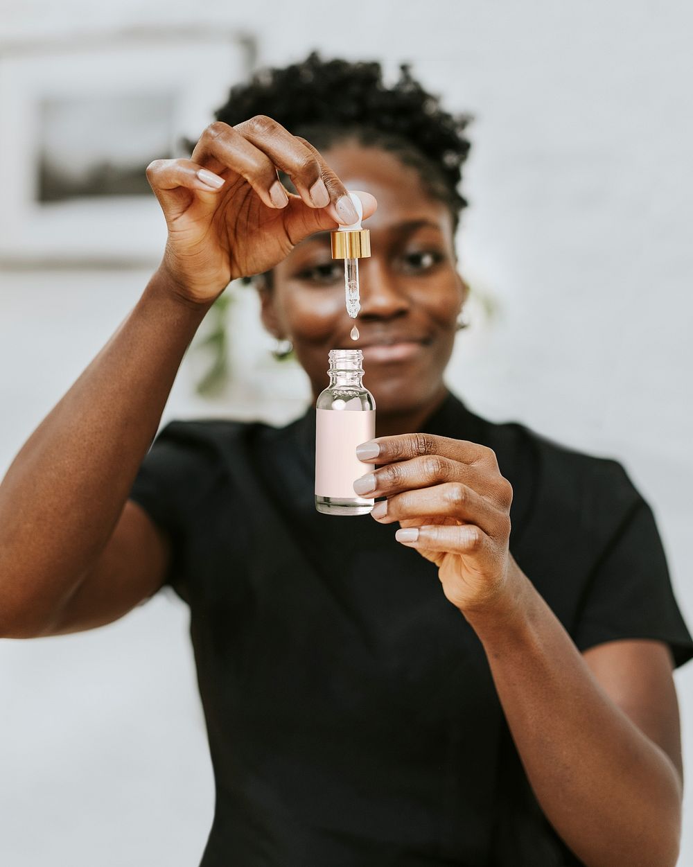 Smiley woman holding dropper bottle 