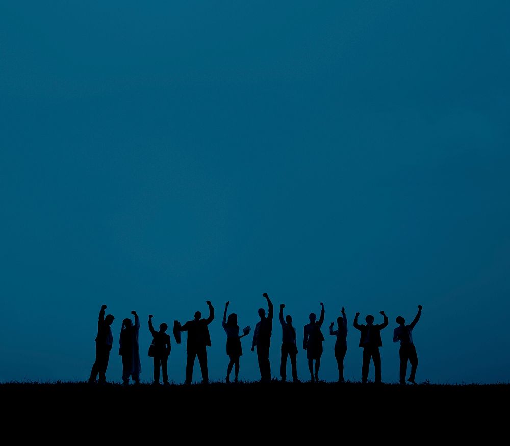 silhouette of business people with arms raised