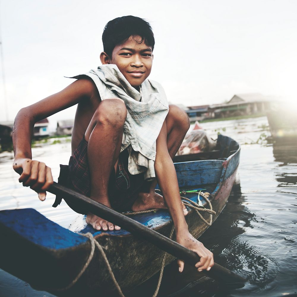 Boy traveling by boat in floating village.
