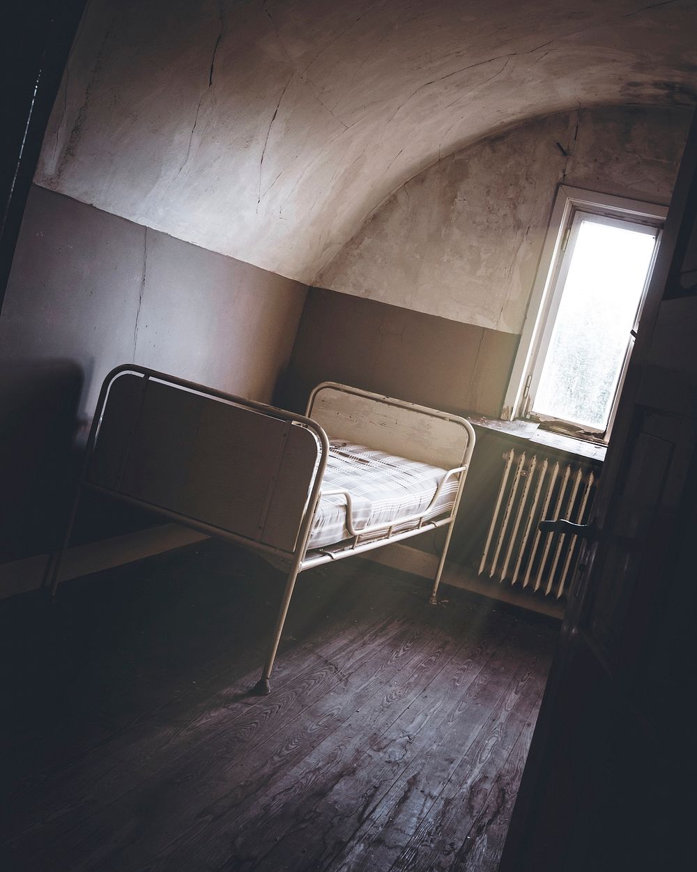 Haunted deserted room with a single bed
